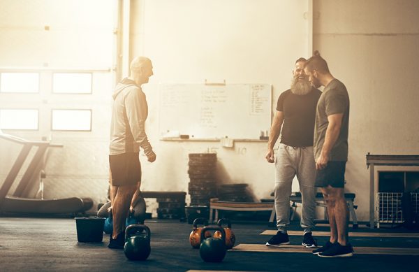 alt = "men cross fit kettle bells"