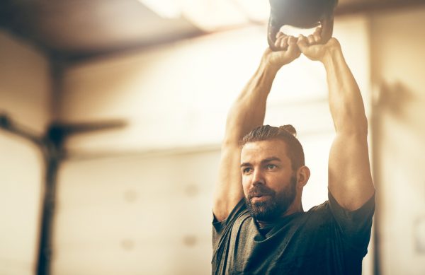 Young man working out at the gym with a dumbbell